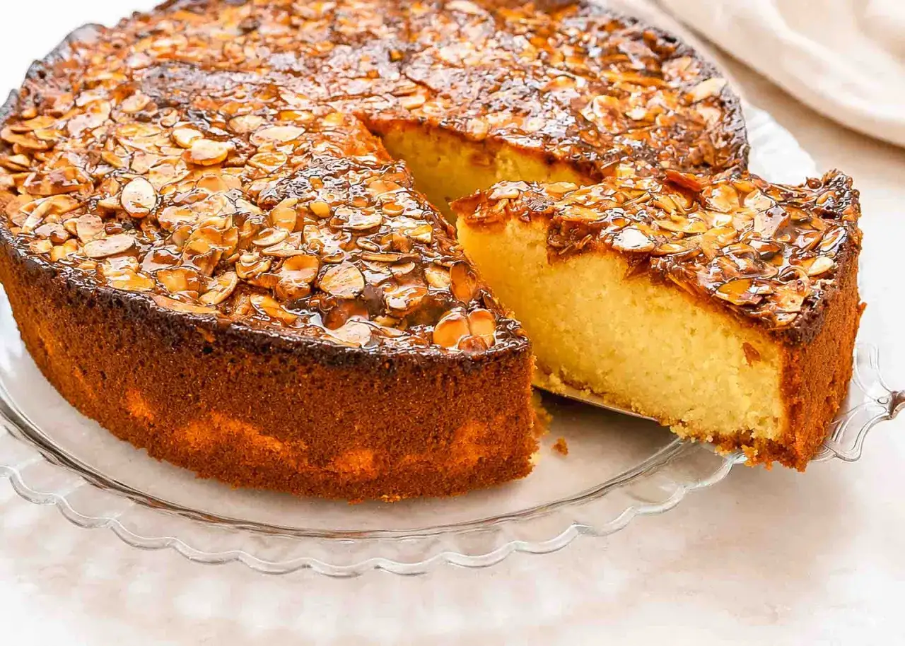 Ein goldbrauner Mohnkuchen mit karamellisierten Mandelblättchen, ein köstliches mandelkuchen rezept.