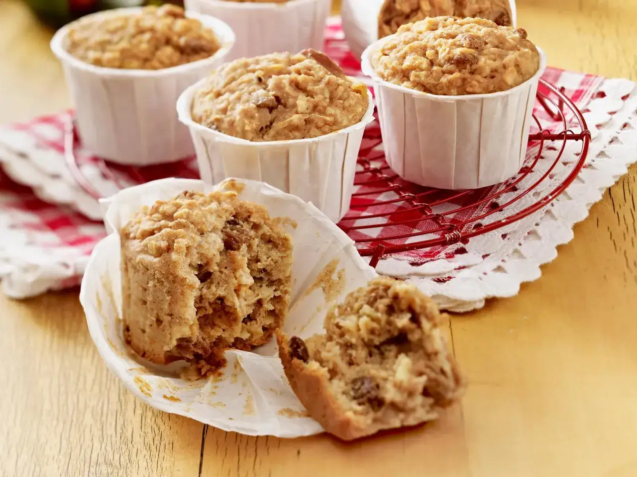 Saftige haferflocken muffins, einige im Papierförmchen, einer zerbrochen, mit Rosinen und Nüssen.