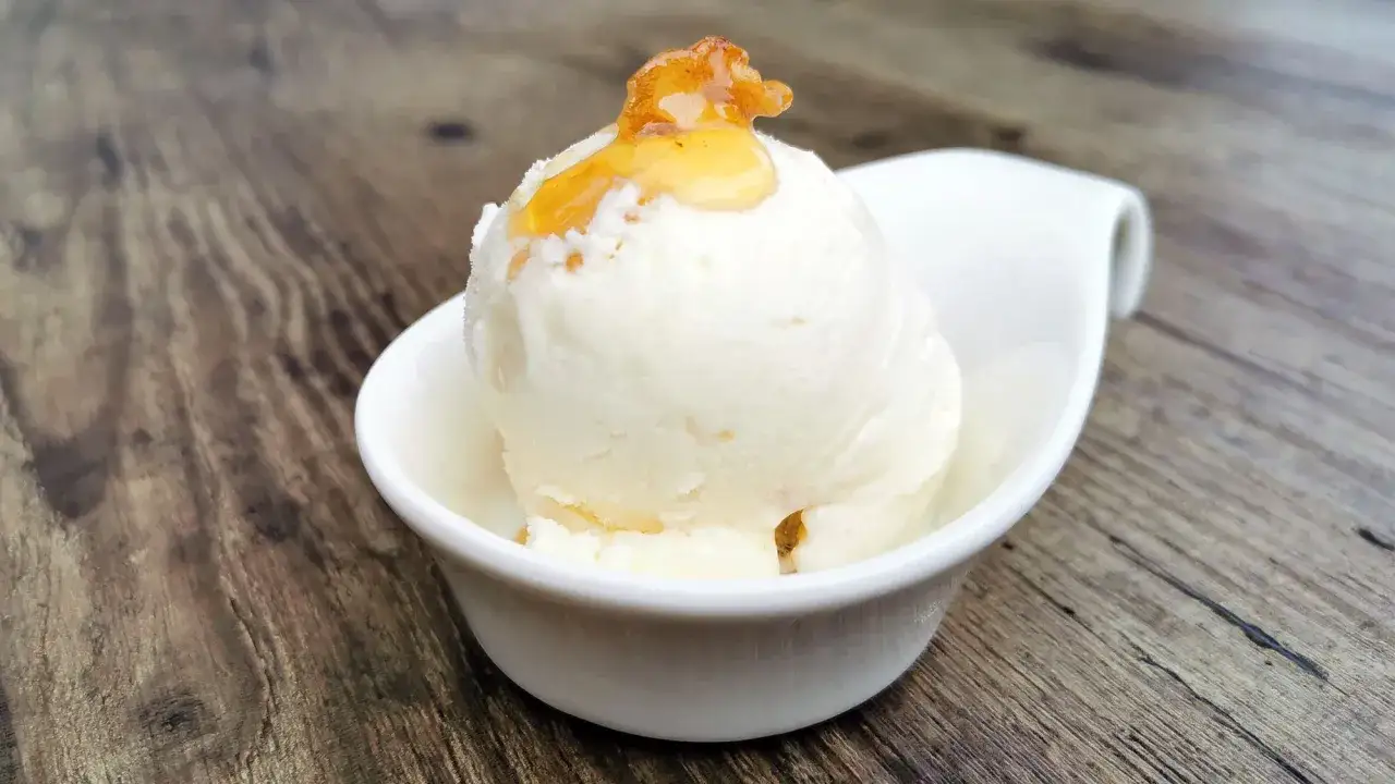 Cremiges griechischer joghurt eis ohne eismaschine, gekrönt mit honig. Köstlich und einfach!
