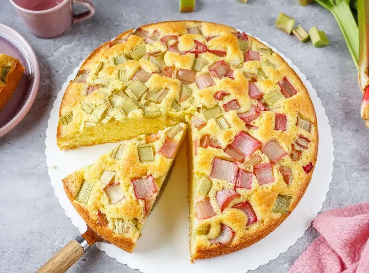 Ein saftiger, schneller Rhabarberkuchen mit vielen roten und grünen Rhabarberstücken, bereit zum Genießen.