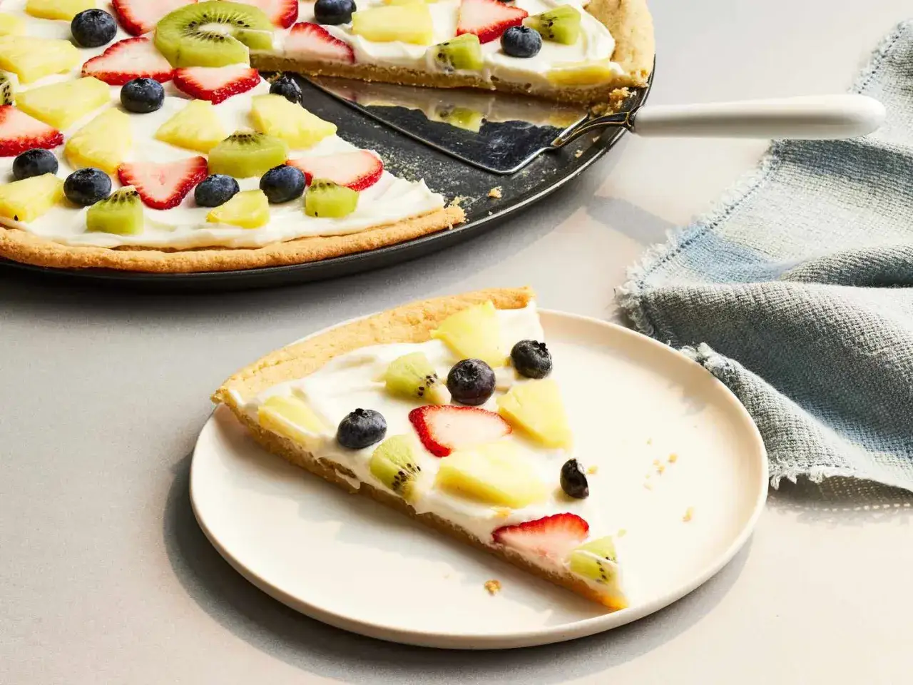 Fruchtige eis pizza mit Erdbeeren, Kiwi, Ananas und Blaubeeren auf cremigem Frischk&auml;se. Ein s&uuml;&szlig;er Genuss!