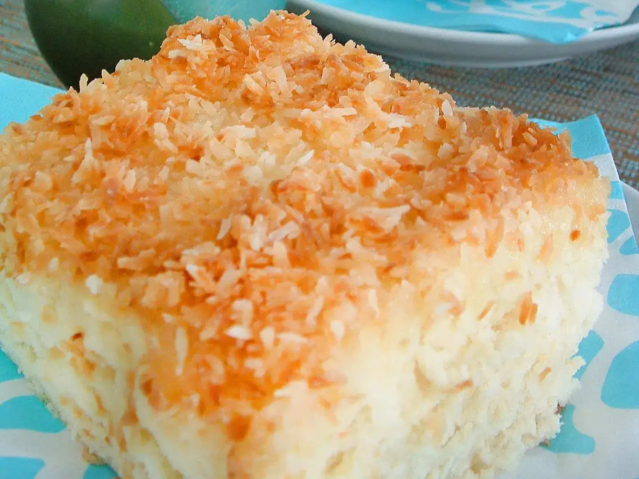 Saftiges Stück Buttermilch-Kokos-Kuchen mit gerösteter Kokosraspelschicht.