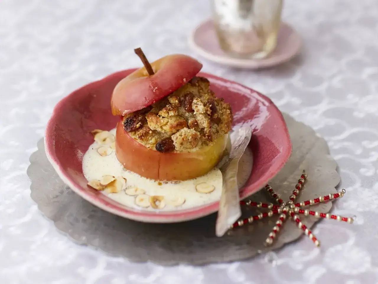 Ein k&ouml;stlicher Bratapfel mit Streuseln, serviert mit Vanillesauce und Mandelsplittern. Ein perfektes Bratapfel Rezept f&uuml;r kalte Tage.