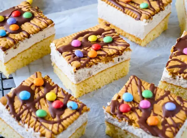 Bunte Geburtstagskuchen für Kinder: saftiger Boden, cremige Füllung, Kekse, Schokoglasur und Smarties.