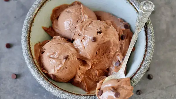 Cremiges schokoladen eis mit zartschmelzenden Schokostückchen in einer rustikalen Schale, bereit zum Genießen.