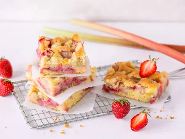 Saftiger Erdbeer Rhabarber Kuchen mit Streuseln, garniert mit frischen Erdbeeren.