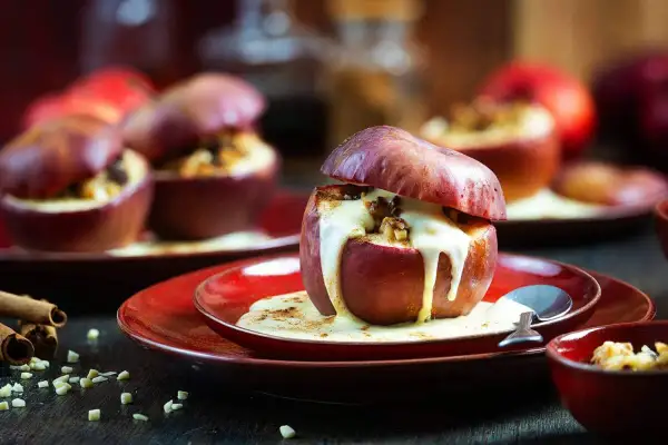 Ein köstliches Bratapfel Rezept: Saftige Äpfel gefüllt mit Nüssen und Zimt, übergossen mit warmer Vanillesauce. Perfekt für kalte Tage.